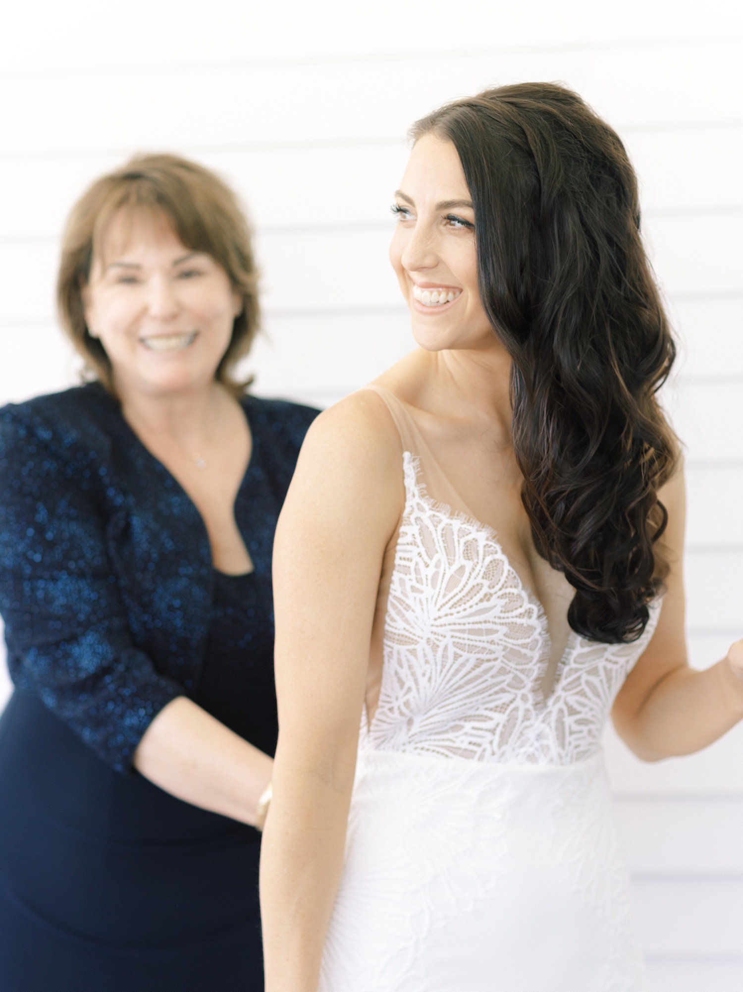 mother helping bride into grace loves lace wedding dress