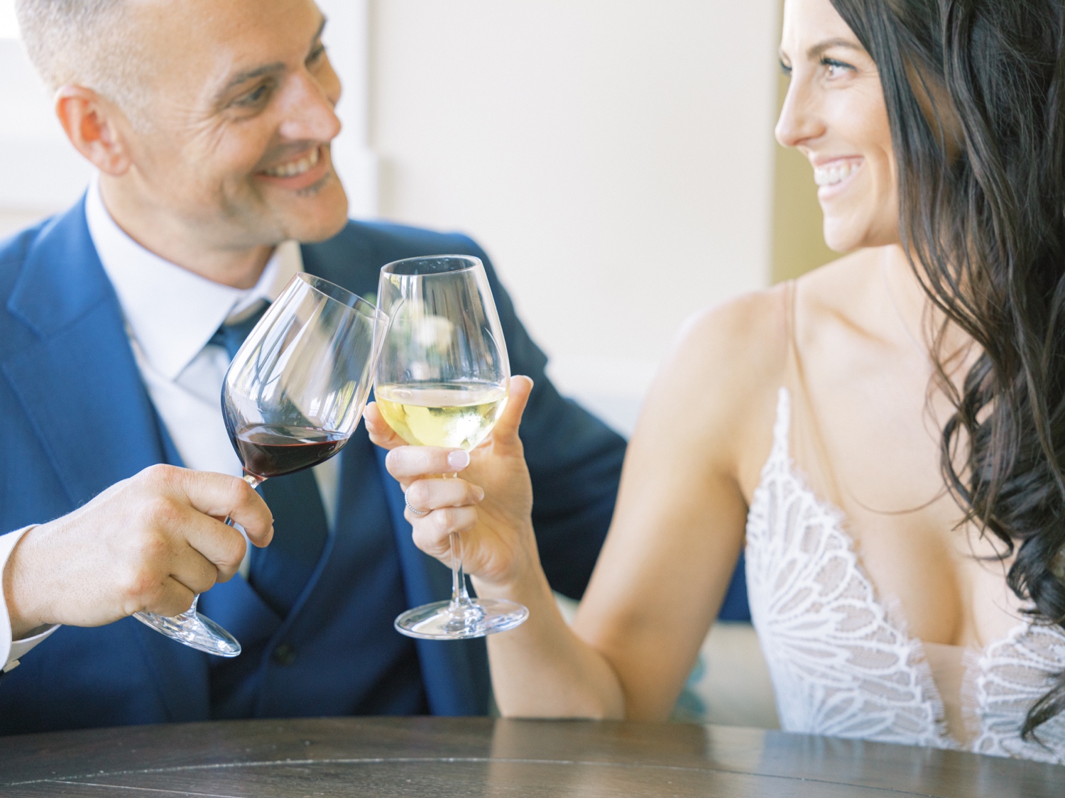 bride and groom clink wine glasses at harmony meadows