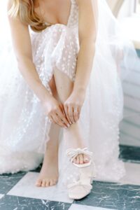 Bride fastening her shoes at Abeja Winery