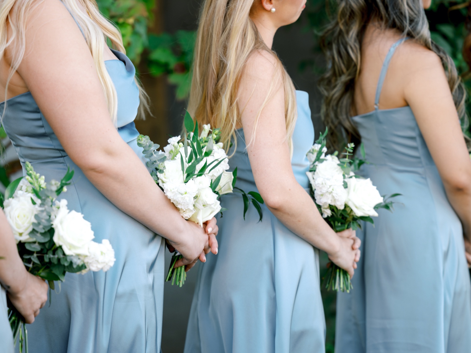 bridesmaids holding wedding bouquets during ceremony