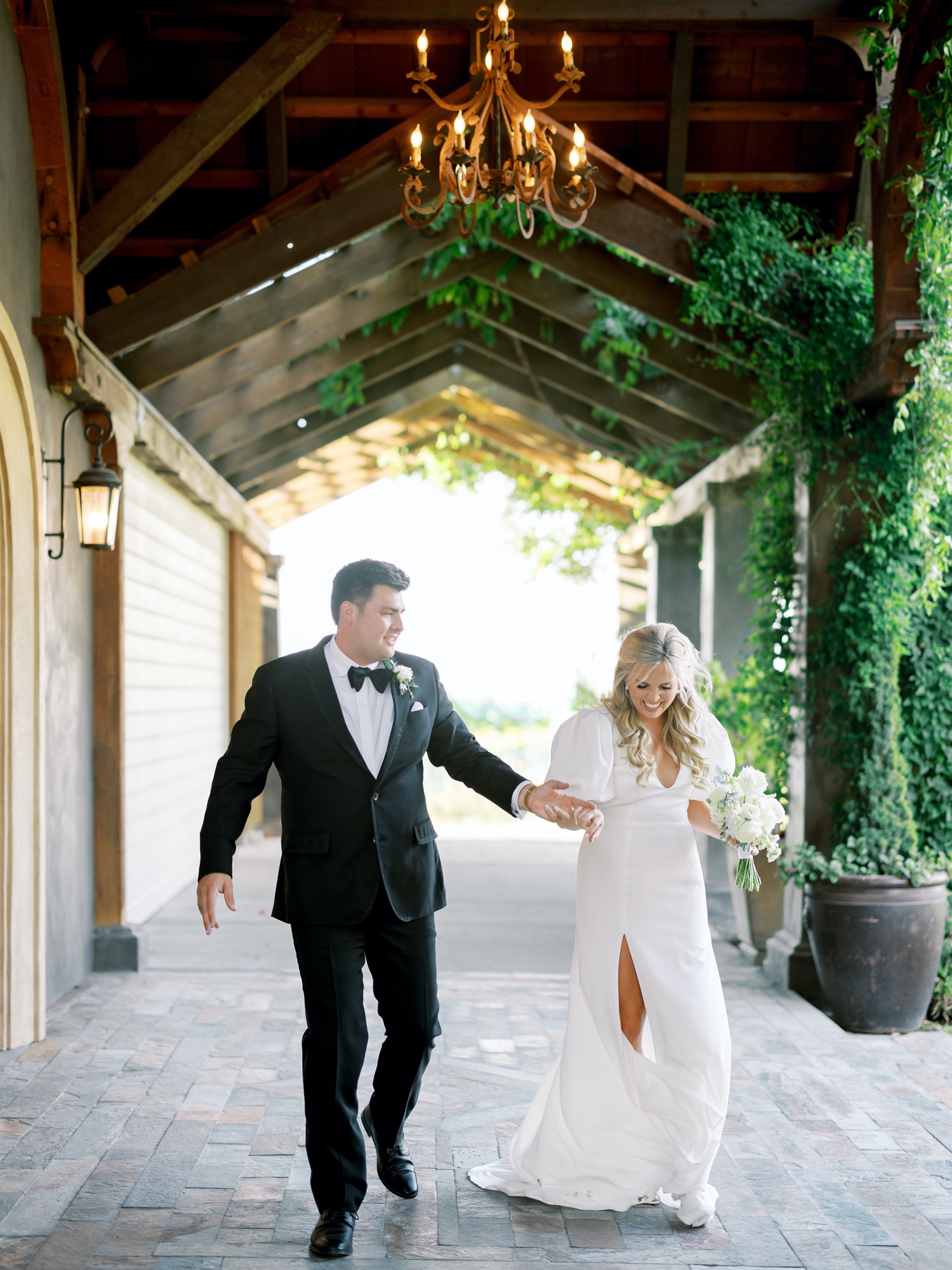 bride and groom walk under the barn to their wedding reception at abeja winery