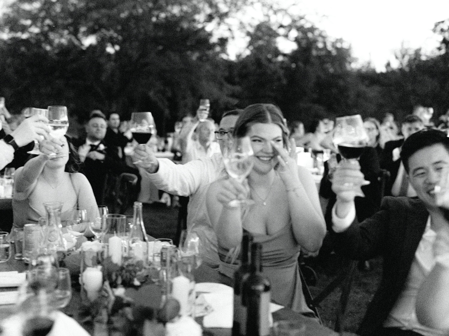 guests raising wine glasses for a toast at abeja winery wedding 