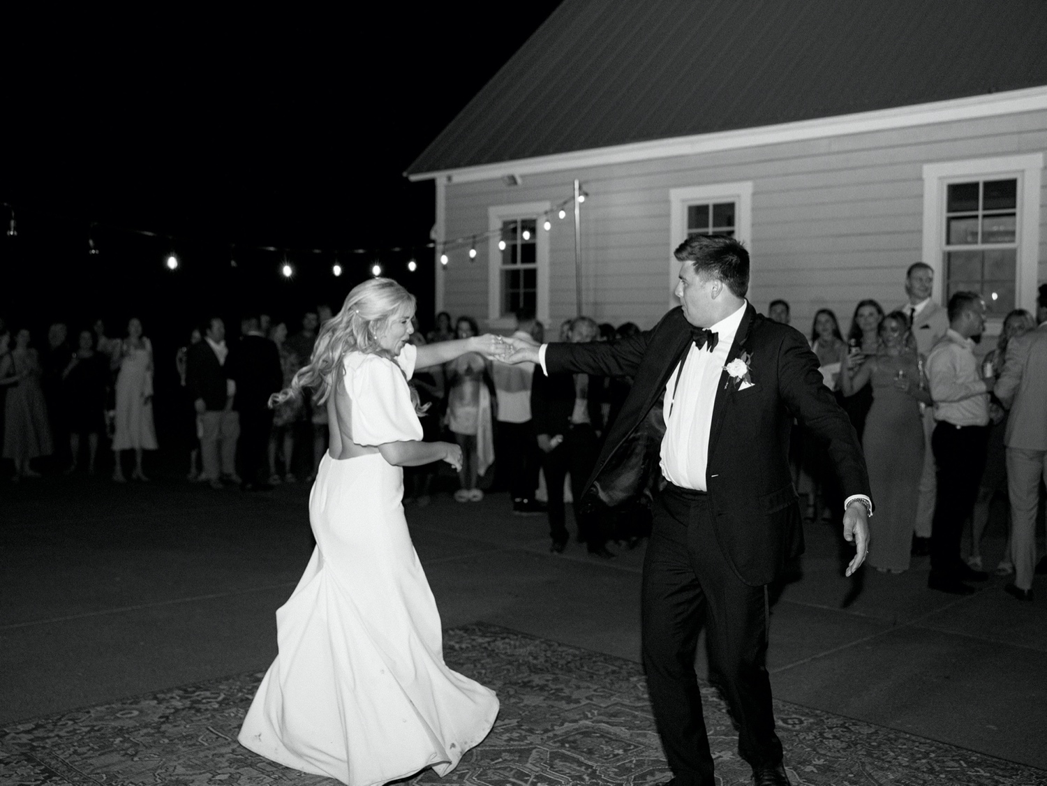 bride and groom share a first dance with guests watching at abeja winery