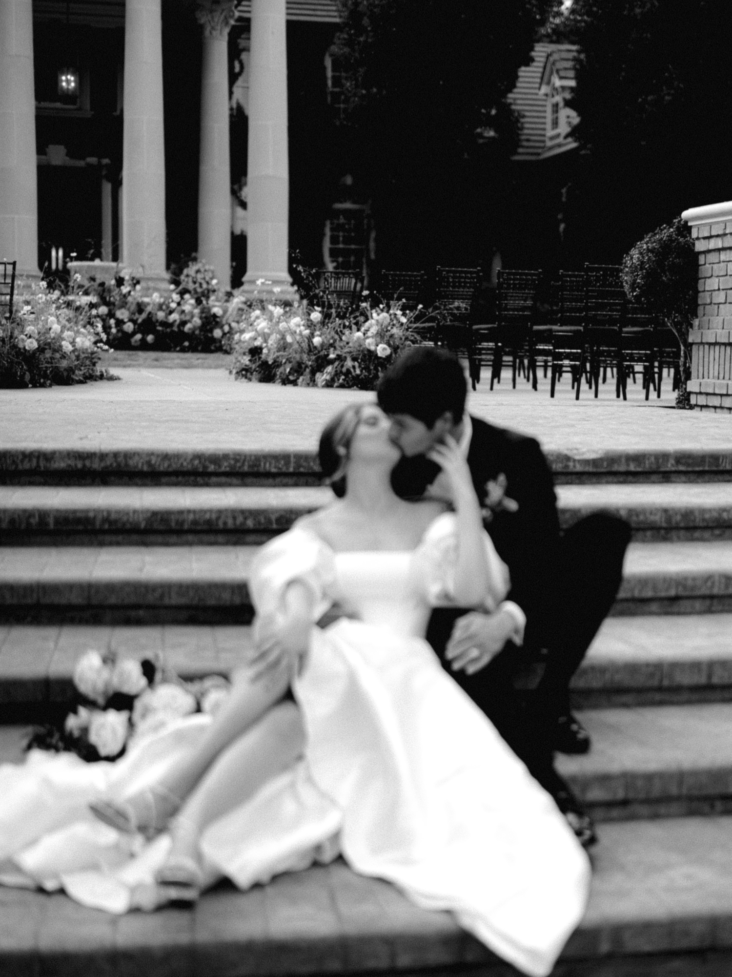 bride and groom share a kiss on the stairs at their oakshire wedding