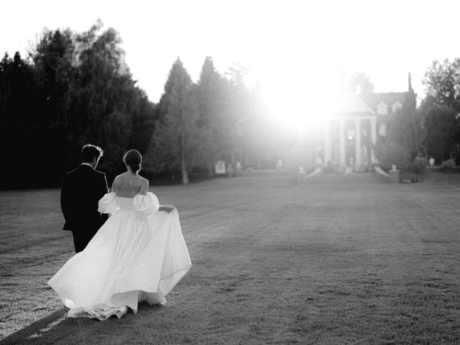 bride and groom walk towards sunset in oakshire estate and airfield wedding