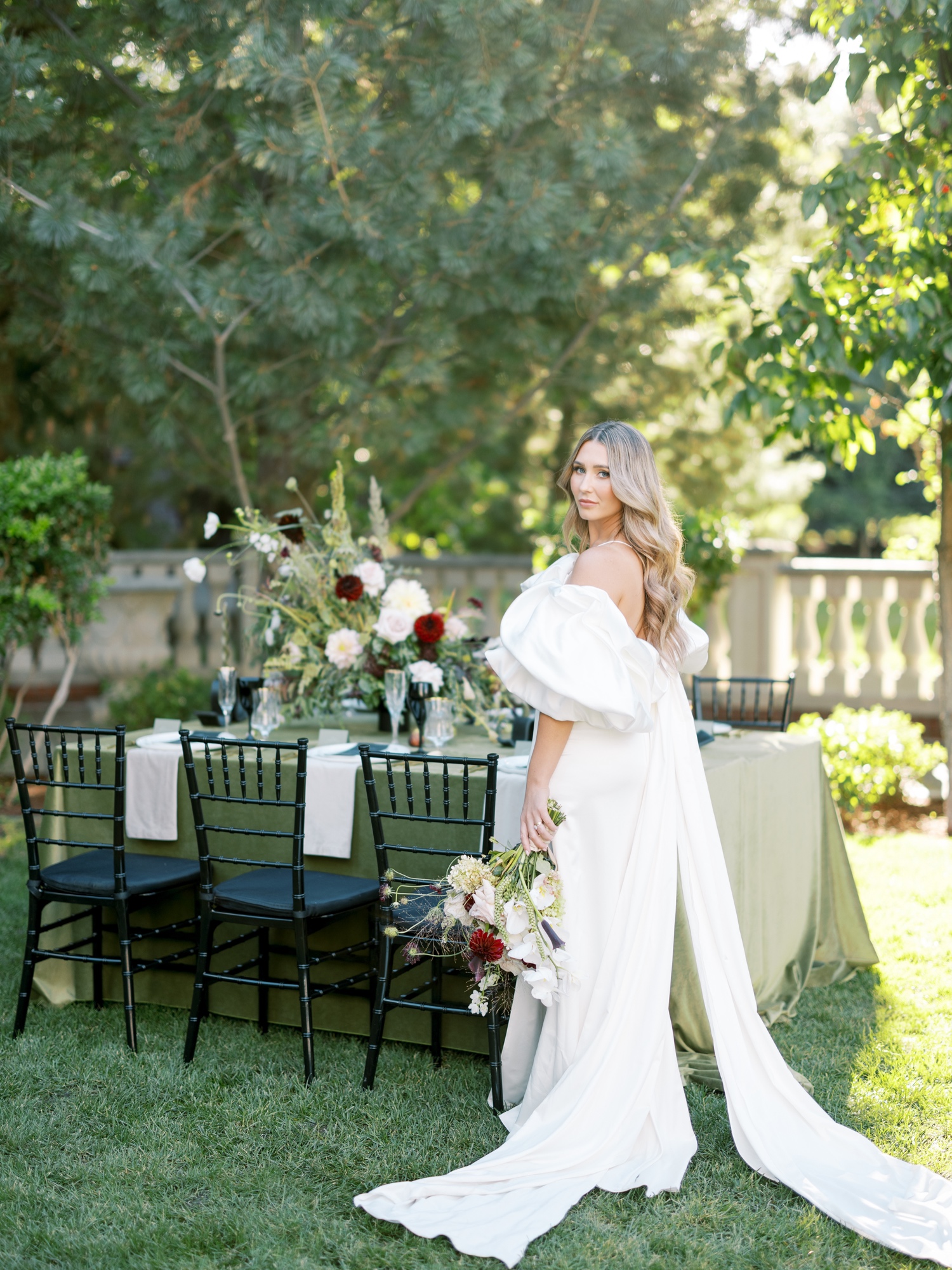 clare de lune bride standing in front of wedding reception table designed by events by edz