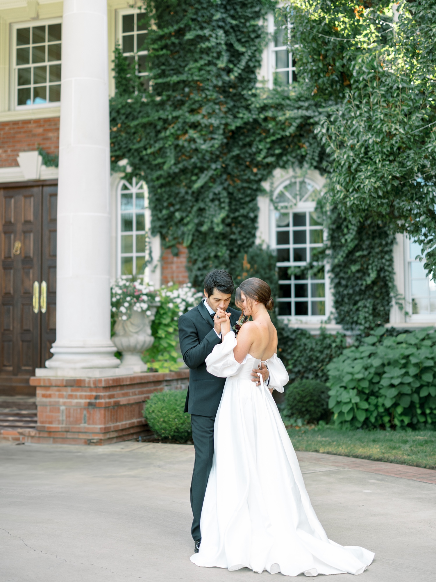 bride and groom share intimate moment in front of the ivy mansion at their oakshire wedding